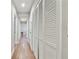 Hallway with hardwood floors, white trim, and ample closet space at 3213 W Cass St, Tampa, FL 33609