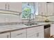 Kitchen features a stainless steel sink, white cabinets, light countertops, and natural light from a window at 3213 W Cass St, Tampa, FL 33609