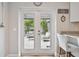 View of a patio from inside, featuring outdoor seating surrounded by lush greenery for ultimate relaxation at 3213 W Cass St, Tampa, FL 33609