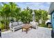 Cozy patio setting with modern outdoor furniture, lush tropical plants, and a neatly paved area at 3213 W Cass St, Tampa, FL 33609