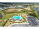 Aerial view of community pool, playground, parking lot, and surrounding neighborhood at 33065 Major Oak Dr, Wesley Chapel, FL 33545