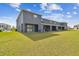 View of gray townhouse, covered patios and green lawn at 33065 Major Oak Dr, Wesley Chapel, FL 33545