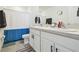 Bright bathroom featuring a double vanity with white cabinetry and a shower with a blue and white curtain at 33065 Major Oak Dr, Wesley Chapel, FL 33545