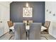 Contemporary dining room with sleek white table, gray chairs, modern lighting, and decorative floral wall art at 33065 Major Oak Dr, Wesley Chapel, FL 33545