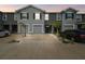 A modern two-story gray townhome with an attached garage, clean landscaping, and a neutral concrete driveway at 33065 Major Oak Dr, Wesley Chapel, FL 33545