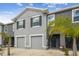 A well-maintained gray townhome with a garage, tidy landscaping, and an inviting entrance at 33065 Major Oak Dr, Wesley Chapel, FL 33545