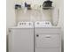 Clean laundry room features a washer, dryer, and storage shelf at 33065 Major Oak Dr, Wesley Chapel, FL 33545