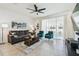 Bright living room with contemporary furniture, ceiling fan, and sliding glass doors leading to the backyard at 33065 Major Oak Dr, Wesley Chapel, FL 33545