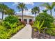 Community pool house entrance with tropical landscaping and walkway. Serene spot for residents to enjoy pool amenities at 33065 Major Oak Dr, Wesley Chapel, FL 33545