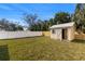 Spacious, fenced backyard featuring a storage shed, grass lawn and mature trees at 3412 71St N St, St Petersburg, FL 33710