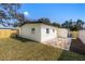 Backyard with a manicured lawn, brick patio, and a white house, partially fenced in, on a sunny day at 3412 71St N St, St Petersburg, FL 33710