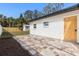 Exterior view of backyard with brick patio, a white house with a wooden door, and a shed in a fenced-in yard at 3412 71St N St, St Petersburg, FL 33710