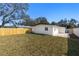 Wide backyard, showing the home's exterior and fenced yard with grass at 3412 71St N St, St Petersburg, FL 33710