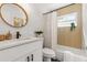 Stylish bathroom features white vanity, round mirror, and shower-tub combination at 3412 71St N St, St Petersburg, FL 33710