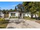 Inviting single-story home with fresh white paint, lush greenery, and a spacious concrete driveway under a blue sky at 3412 71St N St, St Petersburg, FL 33710