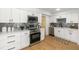 Contemporary white kitchen featuring stainless steel appliances, tile backsplash, and sleek countertops at 3412 71St N St, St Petersburg, FL 33710