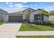 Charming single-story home with a well-manicured lawn, gray trim, and an attached two-car garage at 36642 Garden Wall Way, Zephyrhills, FL 33541