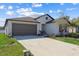 Well-maintained single-story home with gray trim, landscaped front yard and a two-car garage at 36642 Garden Wall Way, Zephyrhills, FL 33541