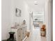 Bright hallway featuring white walls, tile flooring, and decor with a view to the living room at 36642 Garden Wall Way, Zephyrhills, FL 33541