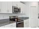 Modern kitchen featuring stainless steel appliances and white cabinetry at 36642 Garden Wall Way, Zephyrhills, FL 33541