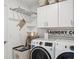 Convenient laundry room features modern appliances, storage cabinets, and stylish decor at 36642 Garden Wall Way, Zephyrhills, FL 33541