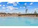 A sunny view of a crystal clear community swimming pool with lounge chairs and blue sky in the background at 36642 Garden Wall Way, Zephyrhills, FL 33541