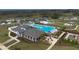 Aerial of a resort style community pool with surrounding homes, palm trees, and chairs for lounging at 36642 Garden Wall Way, Zephyrhills, FL 33541