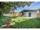 View of the home's fenced backyard, with an expansive lawn and modern painted brick at 3908 W Laurel St, Tampa, FL 33607