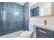 Beautiful bathroom featuring blue tiled shower, modern fixtures, vanity with storage and mosaic tile floor at 3908 W Laurel St, Tampa, FL 33607