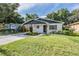 Charming single-story home with white brick, stylish carport, manicured lawn, and garden beds at 3908 W Laurel St, Tampa, FL 33607