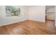 Inviting living room features hardwood floors, a window with blinds, and a white door at 3908 W Laurel St, Tampa, FL 33607