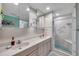 Bright bathroom featuring a double sink vanity, decorative shower, and tiled walls at 399 150Th Ave # 101, Madeira Beach, FL 33708