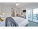 Bedroom featuring ensuite, dresser with TV, and glass doors leading to a terrace at 399 150Th Ave # 101, Madeira Beach, FL 33708