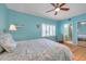 Bright bedroom with a ceiling fan, light blue walls, and an ensuite bathroom at 399 150Th Ave # 101, Madeira Beach, FL 33708