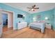 Turquoise bedroom with wood floors, ceiling fan, and accent lighting at 399 150Th Ave # 101A, Madeira Beach, FL 33708