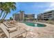 View of the pool with surrounding lounge chairs, building, and the poolside pavilion at 399 150Th Ave # 101, Madeira Beach, FL 33708