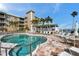 Resort-style pool area with lounge chairs and a charming poolside pavilion, surrounded by lush palm trees at 399 150Th Ave # 101, Madeira Beach, FL 33708