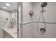 Shower with a rainfall shower head and dispenser, next to a double sink vanity in a bright bathroom at 399 150Th Ave # 101A, Madeira Beach, FL 33708