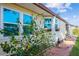 Side exterior shot of the home showing window boxes, multiple windows, and a landscaped area at 411 Dolphin S Dr, Oldsmar, FL 34677