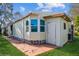 Exterior view of home's side featuring a bay window bumpout, access door, and vinyl siding at 411 Dolphin S Dr, Oldsmar, FL 34677