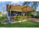 Exterior shot showing extended carport, small front porch, and surrounding landscaping at 411 Dolphin S Dr, Oldsmar, FL 34677