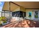 Front exterior of home showing covered carport, enclosed porch, and manicured landscaping at 411 Dolphin S Dr, Oldsmar, FL 34677