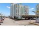 Exterior view of a tall condominium building with covered parking and well-maintained landscaping at 420 64Th Ave # 402, St Pete Beach, FL 33706