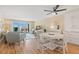 Bright living room with dining area featuring a slider to the balcony and wood paneled wall at 420 64Th Ave # 402, St Pete Beach, FL 33706