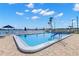 Community pool with a waterfront view, lounge chairs, and a well-maintained deck at 420 64Th Ave # 402, St Pete Beach, FL 33706