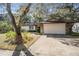 A single-Gathering home showcasing a two-car garage and a cozy front yard with an inviting walkway and an American flag at 421 Wayfarer Ct, Tarpon Springs, FL 34689