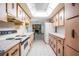 Long kitchen view with adjacent living space, featuring vintage cabinets and appliances at 421 Wayfarer Ct, Tarpon Springs, FL 34689