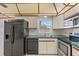 Functional kitchen with white cabinets, stainless steel appliances, and tiled backsplash, ready for cooking at 4435 34Th N Ave, St Petersburg, FL 33713