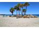 Scenic beach with soft sand, clear water, and inviting seating areas, perfect for relaxation and waterfront enjoyment at 4812 Jasper Dr Dr # 101, New Port Richey, FL 34652