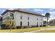 Exterior of a white condo building with manicured lawn and tropical landscaping near the water at 4812 Jasper Dr Dr # 101, New Port Richey, FL 34652